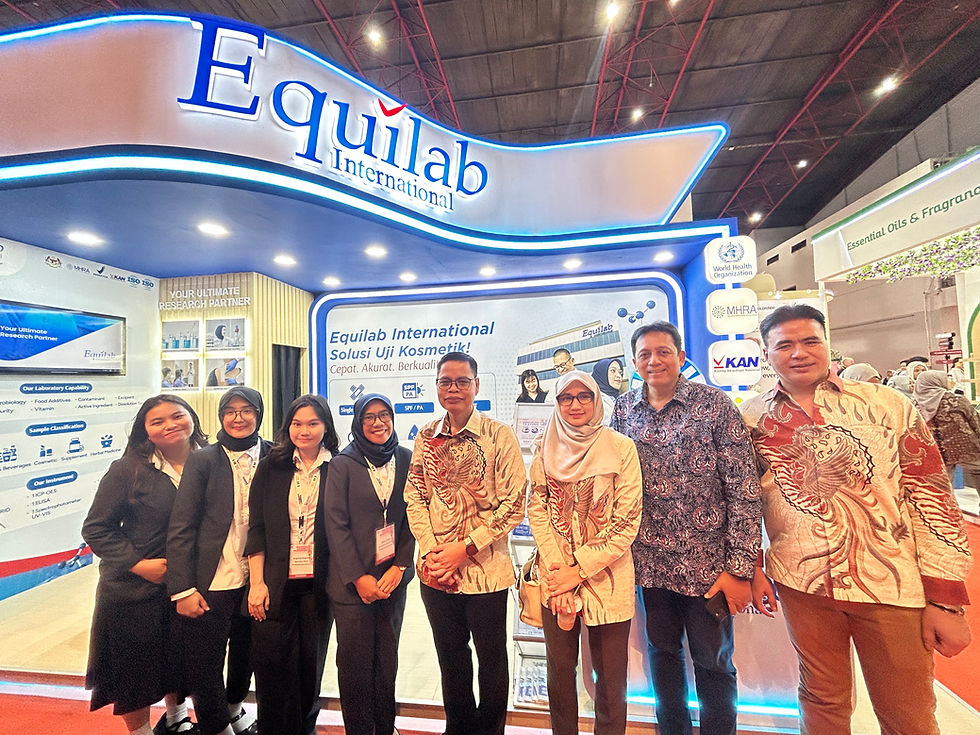 A group of eight people smiling in front of a trade booth for Equilab International. Booth features bright signage and displays.