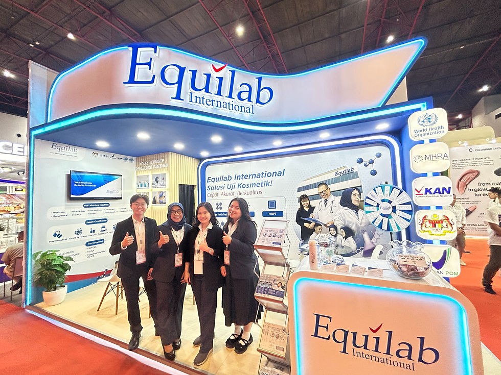 Four people pose in front of the Equilab International booth at a trade show. The booth features blue accents, logos, and promotional posters.